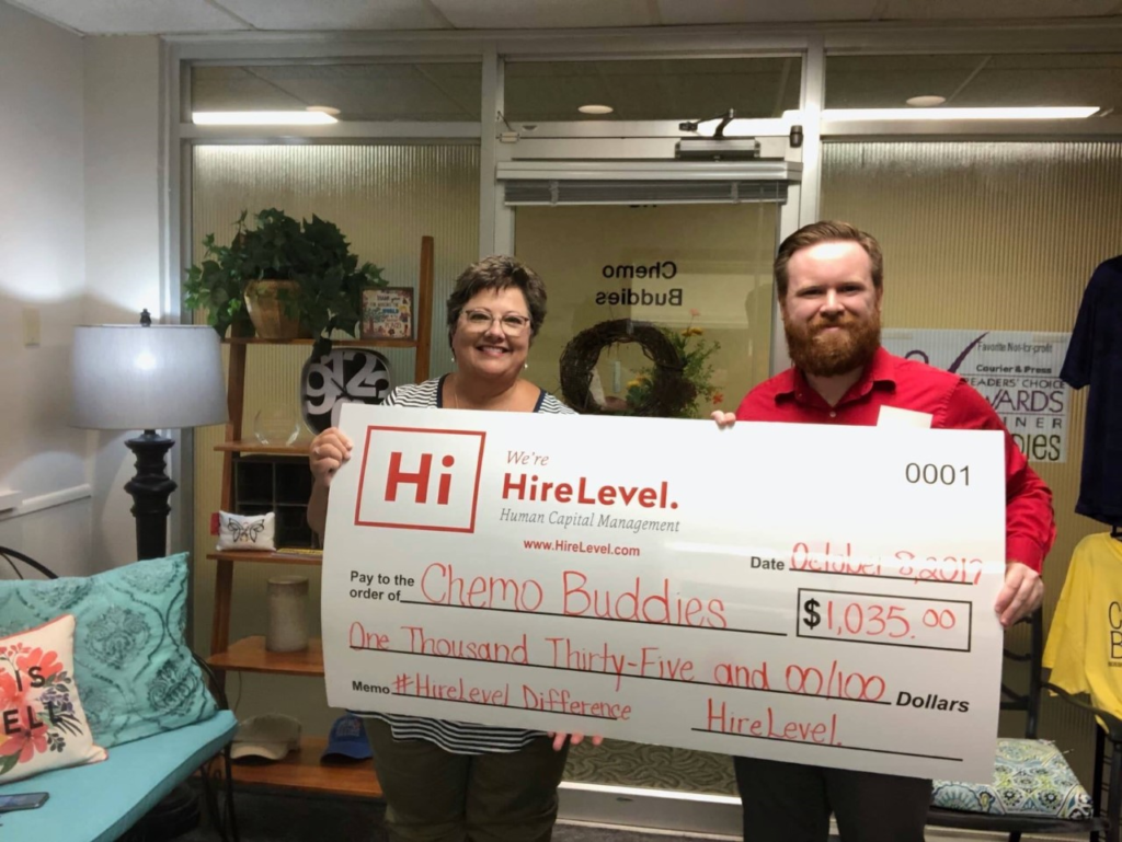 HireLevel gives back-employees holding donation check